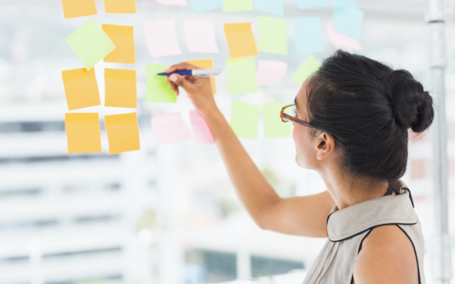 Image of a person writing on sticky notes.